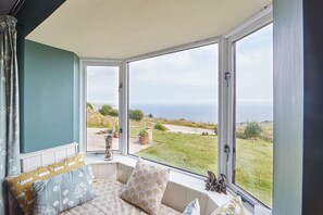 A cozy seating area with a view of the sea and a garden. - Host Stay Fairview House (Scarborough)