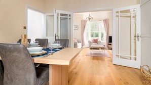 Comedor con una mesa de madera dispuesta para cuatro personas, rodeada de sillas grises tapizadas.