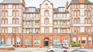 A multi-story building with a central entrance, large windows, and a balcony on the second floor. - Host Stay Sea View 44 (Whitby)