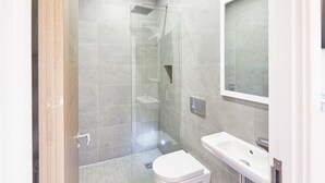 Ein modernes Badezimmer mit einer Duschkabine, Toilette und Waschbecken.