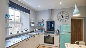 Une cuisine moderne équipée d’un four encastré, d’un grille-pain et d’un réfrigérateur au style rétro.