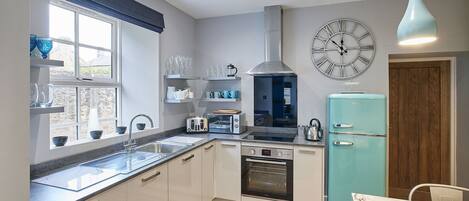 A modern kitchen with a built-in oven, a toaster, and a vintage-style refrigerator.