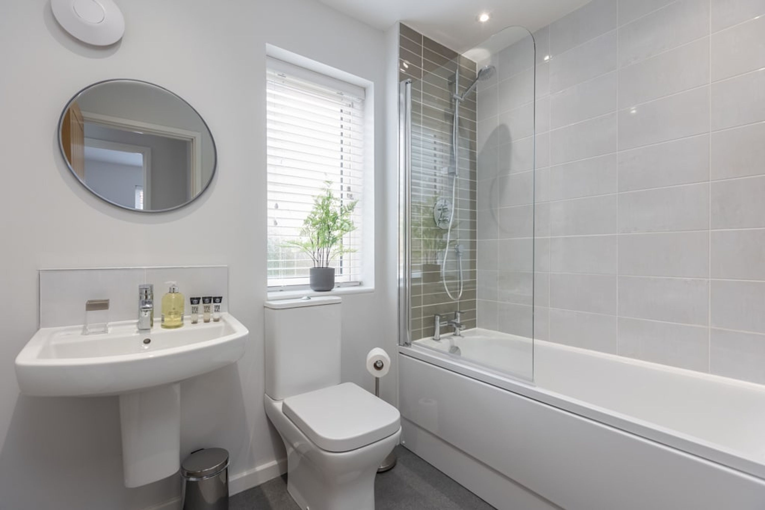 Un bagno moderno con lavandino, water e vasca da bagno bianchi.