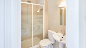Ein modernes Badezimmer mit Glasdusche, Toilette und Waschbecken.