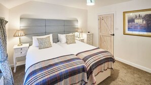A neatly arranged bedroom with a large bed, two bedside tables, a headboard, a wardrobe, and a framed picture on the wall. - Host Stay Willow Cottage (York)