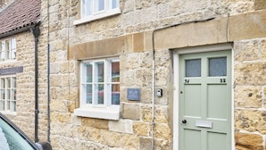 A stone building with a green door labeled "34" and "32". - Host Stay Willow Cottage (York)