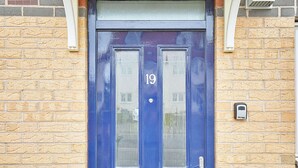 A blue door with the number 19, a mail slot, and a doorbell.