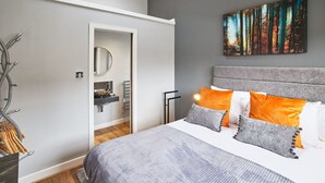 A modern bedroom with a large bed, a headboard, and a painting on the wall. - Host Stay 82F Galgate (Barnard Castle)