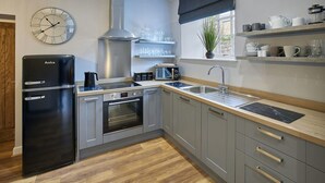 A modern kitchen with grey cabinets, a black refrigerator, a built-in oven, a microwave, and a sink. - Host Stay 82F Galgate (Barnard Castle)