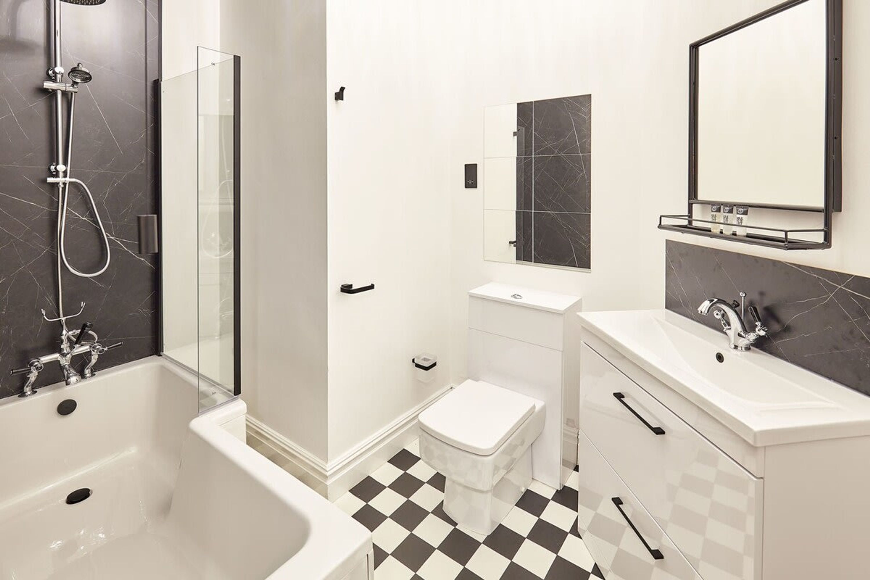 A modern bathroom with a freestanding bathtub, a glass-enclosed shower, a toilet, and a vanity with a mirror.