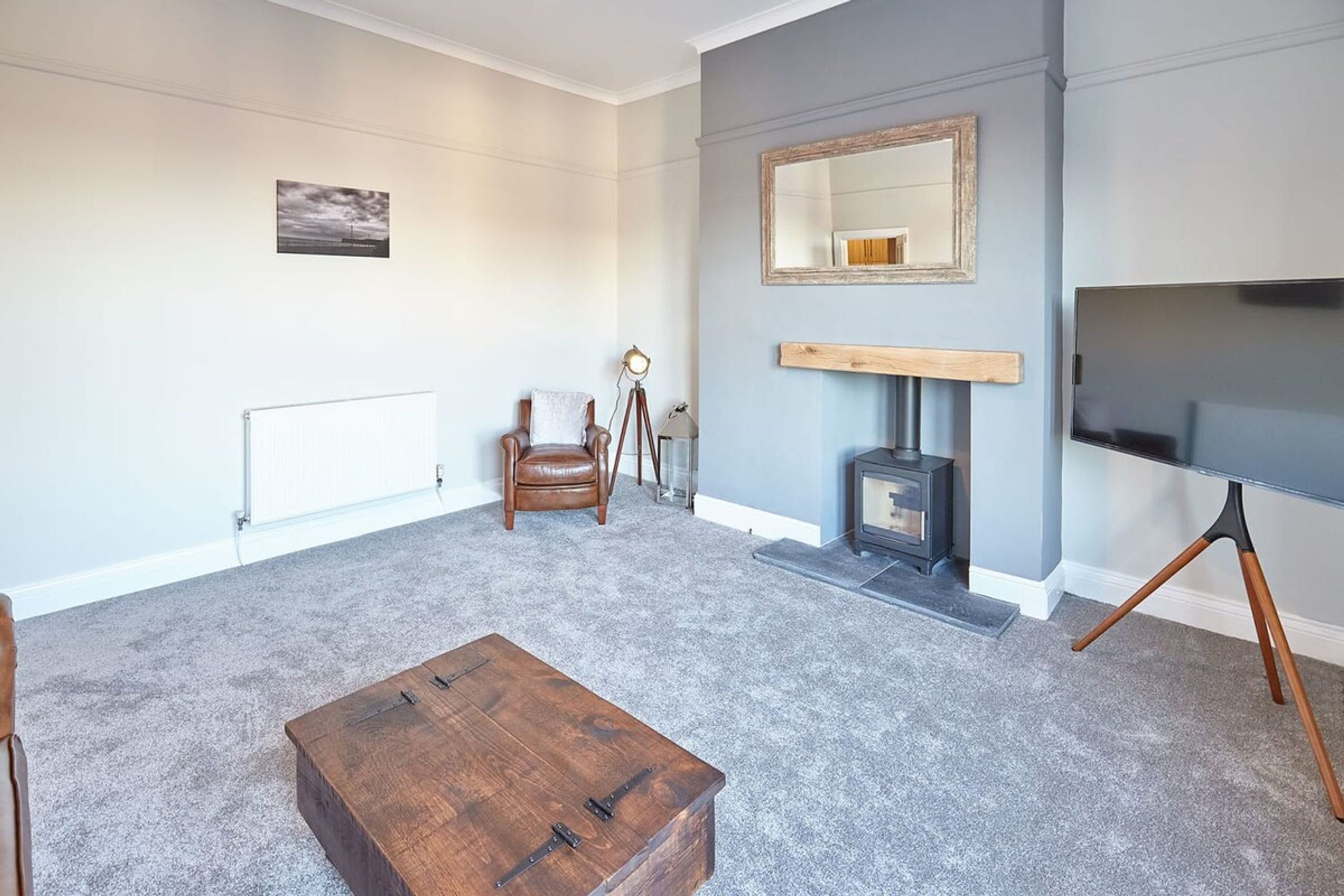 A living room with a fireplace, a television, and a wooden coffee table.