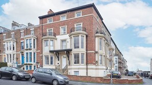 A row of terraced houses with bay windows and a brick facade. - Host Stay Abbey Heights (Whitby)