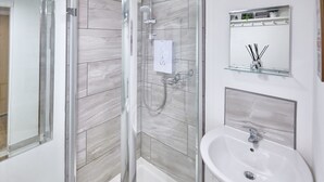 A modern bathroom with a glass-enclosed shower, a white sink, and a mirror above the sink. - Host Stay Abbey Heights (Whitby)