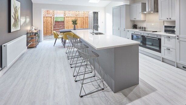 A modern kitchen with a central island, bar stools, and built-in appliances. - Host Stay Littlebeck House Briggswath (Whitby)