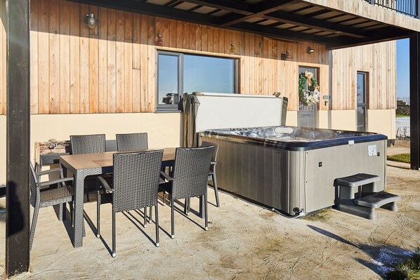 An outdoor patio with a hot tub, wicker chairs, and a wooden table. - Host Stay The Gathering (Newcastle-upon-Tyne)