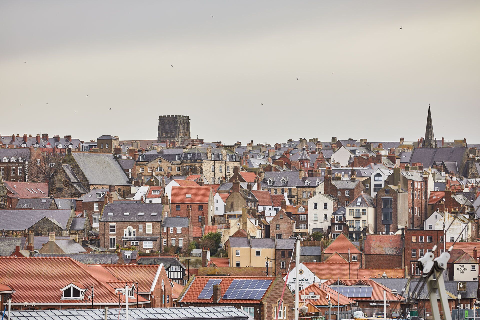A densely packed urban area with historic buildings, including a prominent tower and a spire.