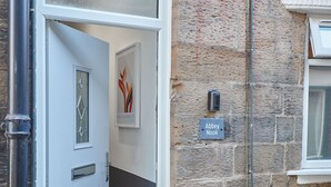A door with a glass panel, a framed artwork, and a sign reading "Abbey Nook". - Host Stay Abbey Nook (Whitby)