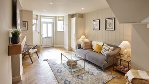 A modern living room with a grey sofa, two side tables with lamps, a glass coffee table, and a patterned rug. - Host Stay The Salt Nook (Whitby)