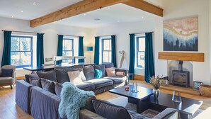 A spacious living room with a large sofa set, a coffee table, and a fireplace. - Host Stay The Lakehouse (Whitby)