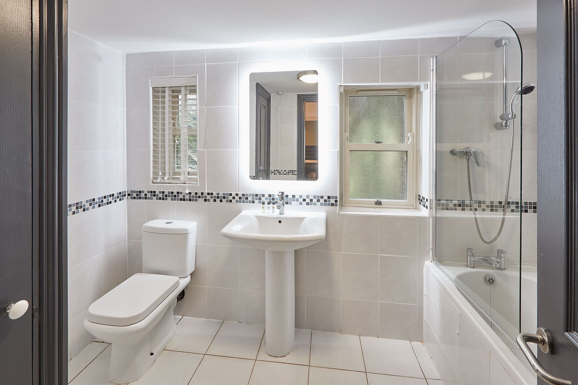 A bathroom with a toilet, sink, and shower.