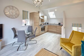 Un appartement moderne comprenant un coin repas, une cuisine et un salon.