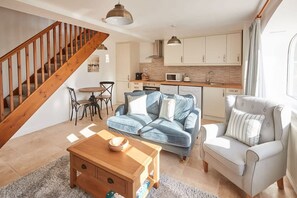 Cozy living space with a staircase, seating area, and kitchen.