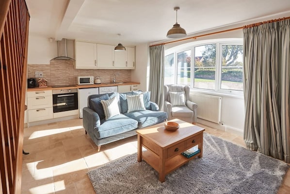 Relax in this open-plan living space with a fully equipped kitchen and comfortable seating area.