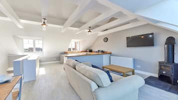 A modern loft apartment with a kitchen, dining area, and living room.