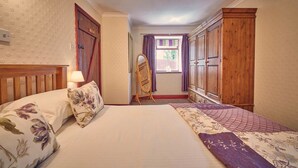 A bedroom with a large bed, wooden wardrobe, and a window with curtains. - Host Stay No 3 Rose Cottage (Belford)