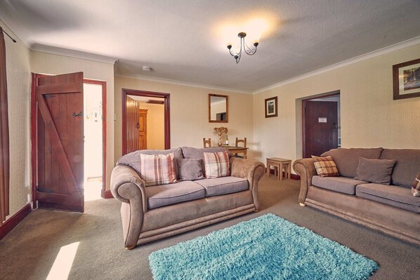 A living room with two sofas, a blue rug, and a chandelier. - Host Stay No 3 Rose Cottage (Belford)