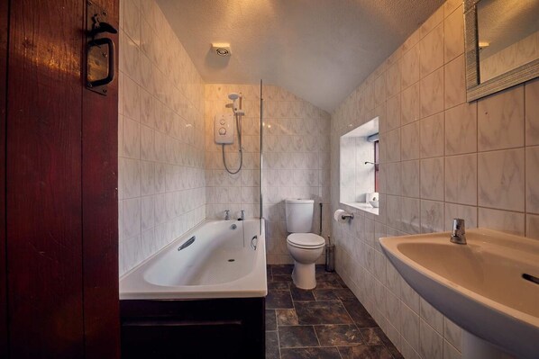 Un baño con bañera, lavamanos e inodoro.
