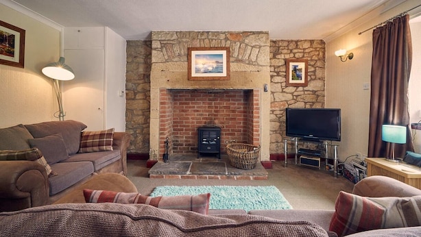 A cozy living room with a stone fireplace, a television, and a sofa. - Host Stay No 3 Rose Cottage (Belford)