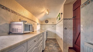 A kitchen with a microwave, cabinets, and a tiled backsplash. - Host Stay No 3 Rose Cottage (Belford)