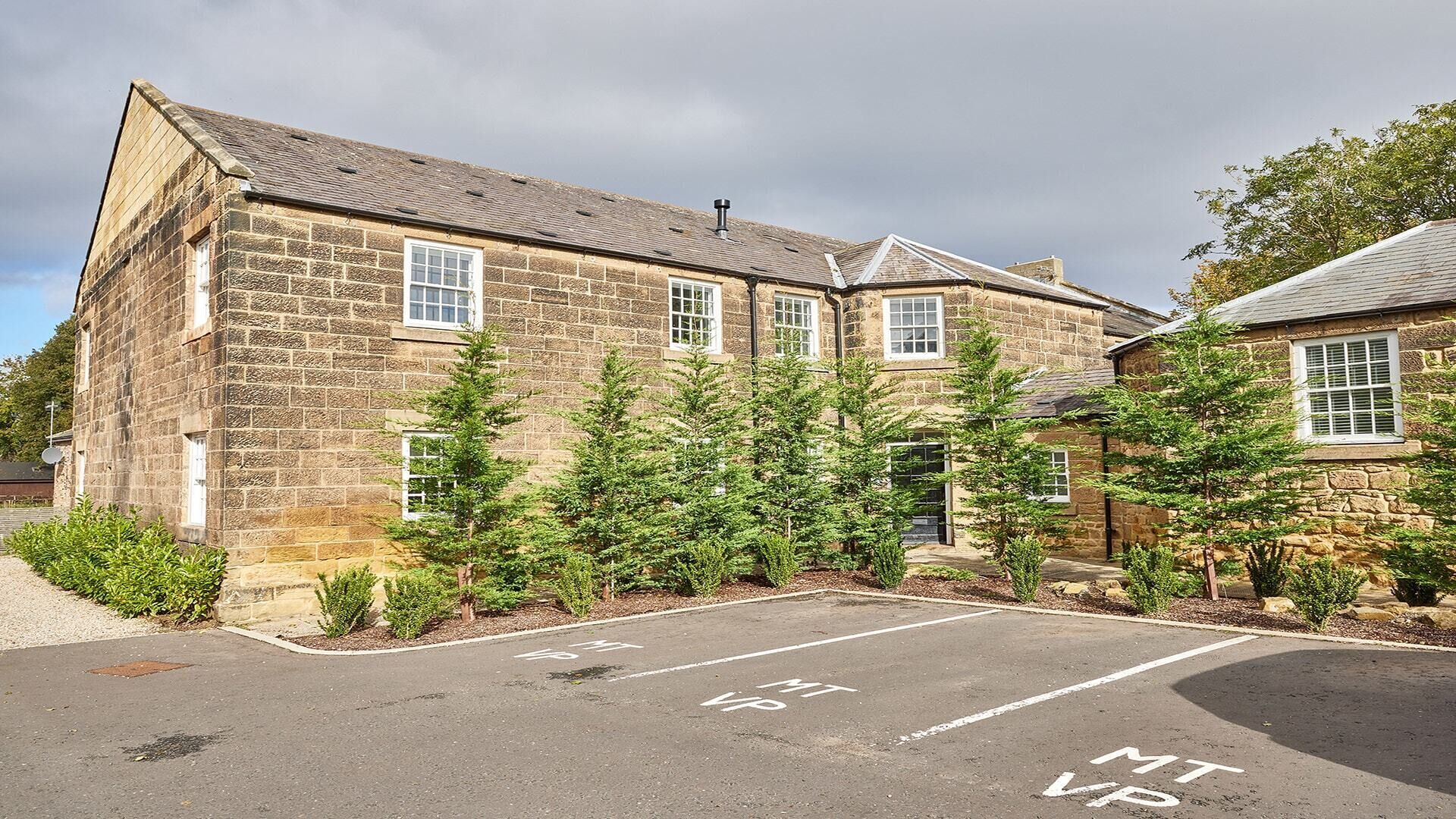A stone building with a parking area marked "MT VP".