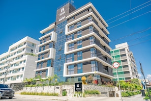 Um hotel de vários andares com design moderno, com varandas e um logotipo bem visível.