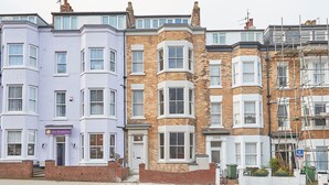 A row of terraced houses with distinct architectural styles, including a corner house with a bay window and a flat with a sign for 'The Boundary'. - Host Stay Anchor Apartment North Marine House (Scarborough)
