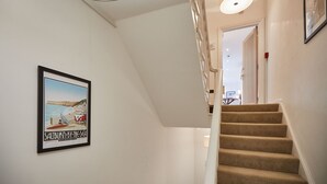 A staircase with carpeted steps leading to a landing, a framed picture on the wall, and a ceiling light fixture. - Host Stay Studio Pod 3 (Saltburn-by-the-Sea)