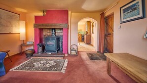 A cozy living room with a fireplace, a rug, and a bench. - Host Stay The Red Brick Barn (Bishop Auckland)