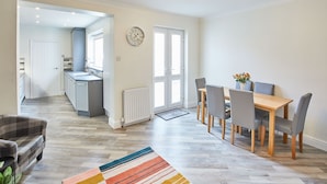 A modern kitchen with a dining area, a sofa, and a rug. - Host Stay 1 Montrose Street (Saltburn-by-the-Sea)