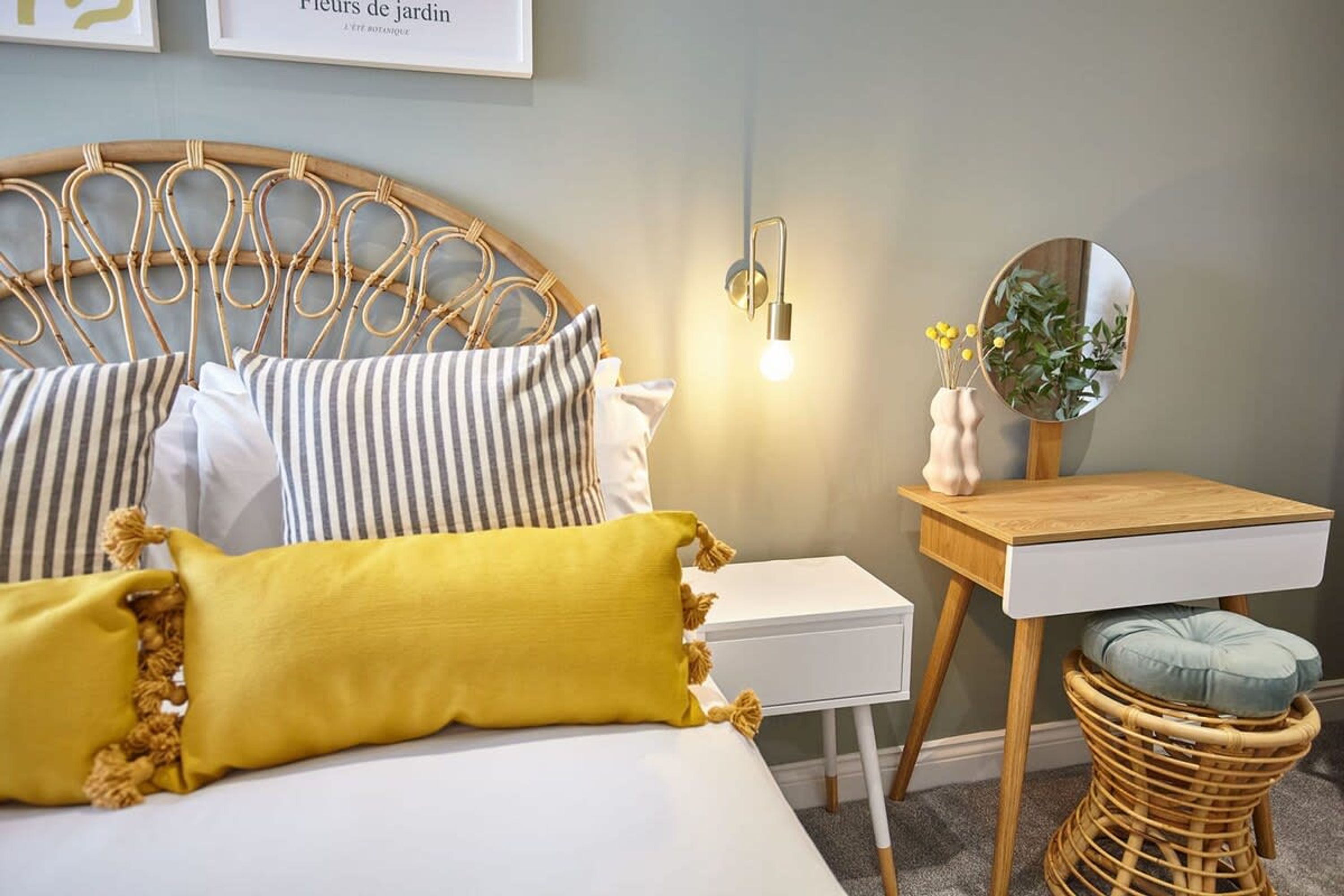 A neatly arranged bedroom with a bed, bedside table, and a small wooden nightstand.
