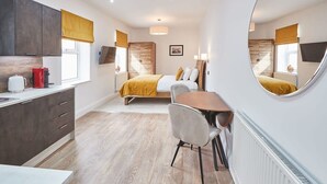 A modern bedroom with a bed, bedside table, and a large mirror. - Host Stay Studio Pod 2 (Saltburn-by-the-Sea)