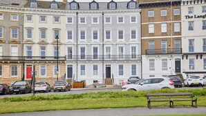 A row of terraced houses with a bench in the foreground.