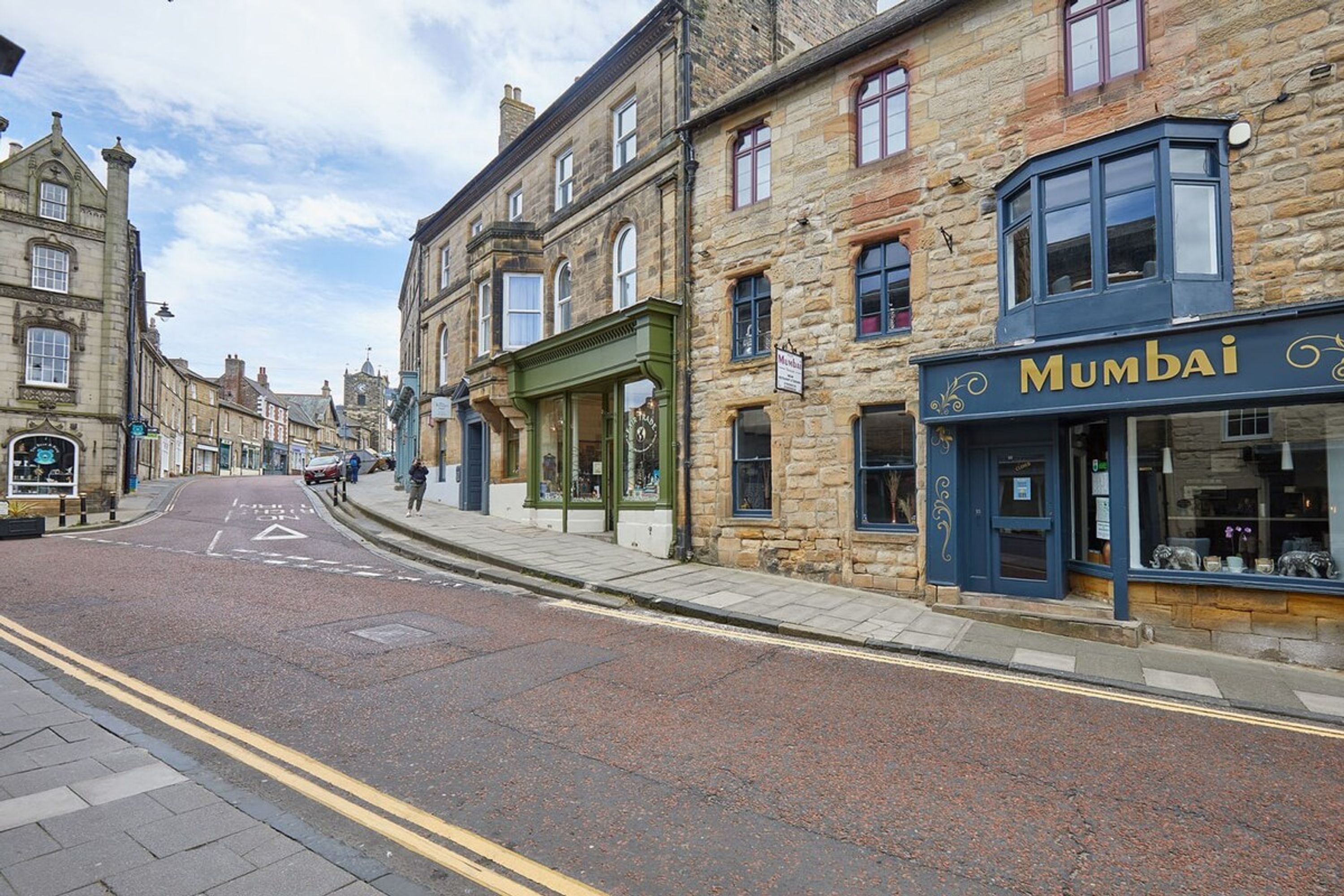A street with buildings, including a shop named 'Mumbai'.