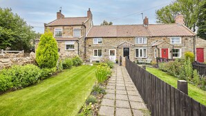 A stone house with a tiled roof, a front garden, and a wooden fence. - Host Stay Honeysuckle Cottage (Saltburn-by-the-Sea)