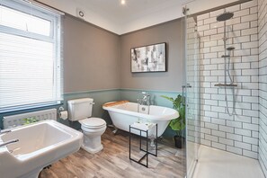 A bathroom with a bathtub, toilet, and shower.
