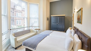 A bedroom with a bed, a sofa, a wardrobe, and a window with blinds. - Host Stay Three Bays (Scarborough)