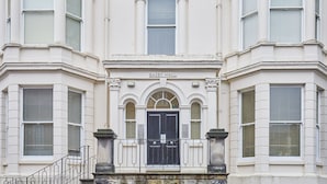 A building with a black double door, a sign reading "EASBY HALL," and a balcony with a metal railing. - Host Stay Three Bays (Scarborough)