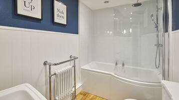 A modern bathroom with a freestanding bathtub, a glass-enclosed shower, and a white toilet.