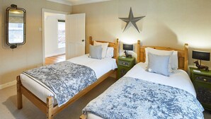 Une chambre d’hôtel avec deux lits, une décoration en forme d’étoile au mur, un miroir et une fenêtre donnant sur un paysage agréable.