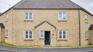 A two-story stone building with a symmetrical facade, a central entrance, and evenly spaced windows. - Host Stay Aynsley Mews (Consett)